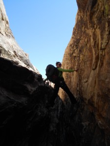 Paige Ashley scrambling above a narrow slot canyon